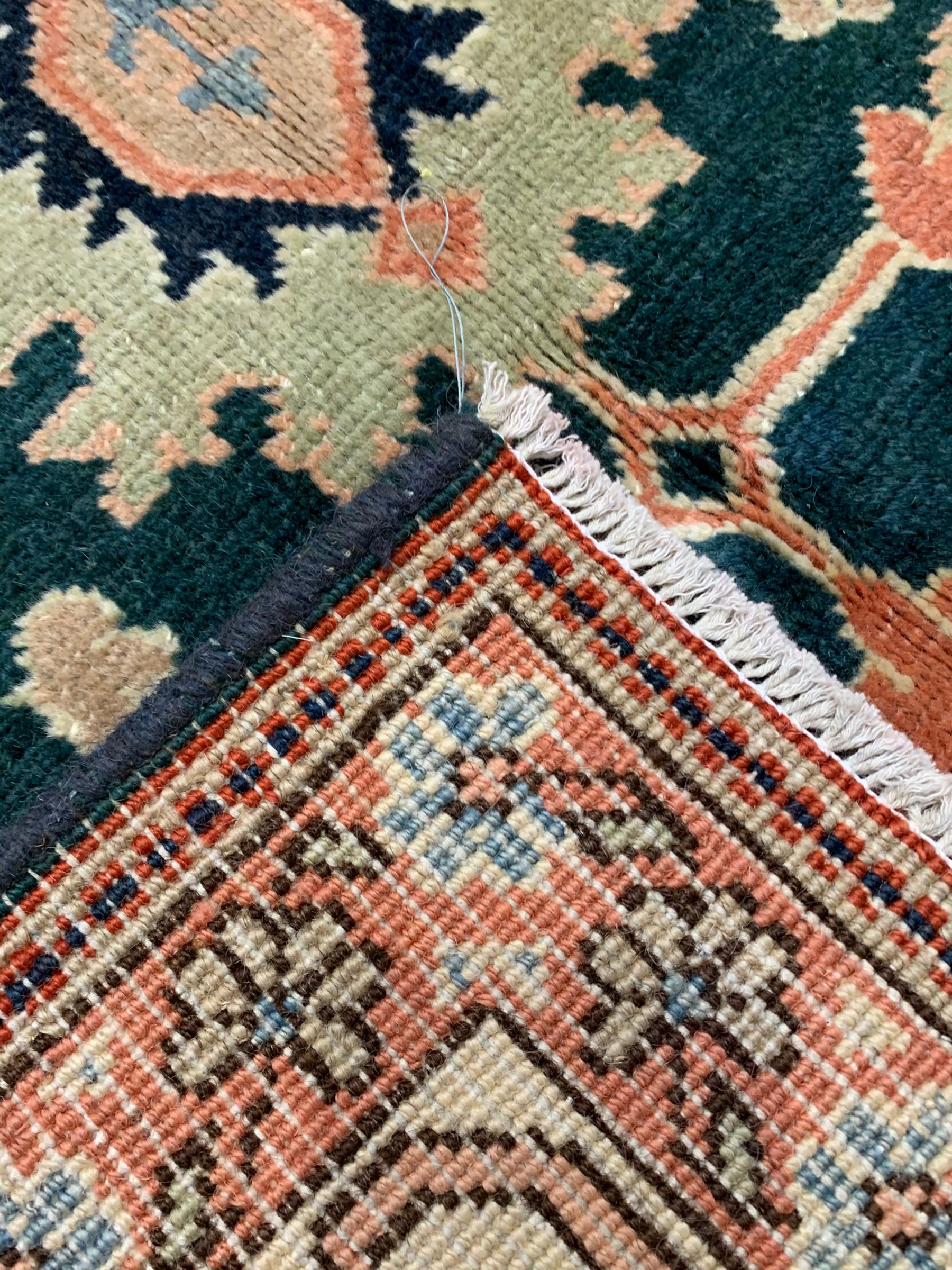 Persian emerald green ground rug, the field decorated with large stylised plant motifs, ivory ground border with repeating leaf motifs, the guards decorated with trailing branch and flowerhead motifs