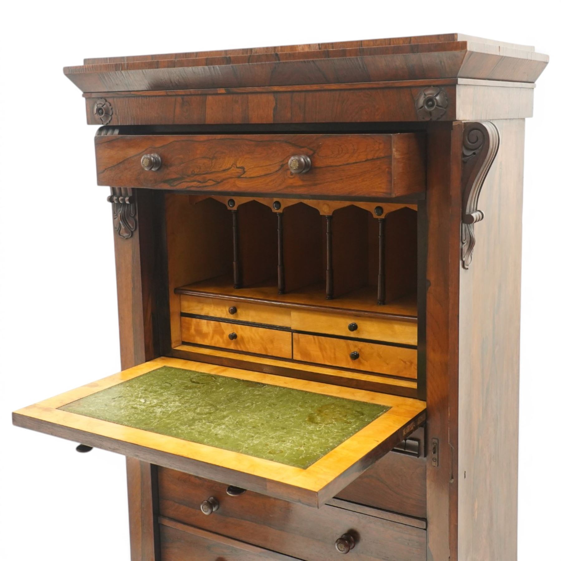 Victorian rosewood Wellington secretaire chest, the projecting stepped cornice over a banded frieze with moulded rosette mounts, single drawer over a secretaire fall-front opening to reveal a maple lined interior with assorted pigeonholes and correspondence drawers, over a lappet carved lower edge with four graduating drawers below, each with turned pull handles, flanked by hinged lock to the right and plain stile to the left surmounted by reeded corbels, raised on a skirted base