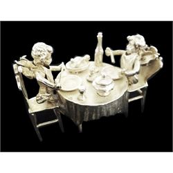 Early 20th century German Hanau silver miniature, modelled as two putti feasting at a dining table laden with food and drink, with Hanau marks for Neresheimer & Sohne, and hallmarked B Muller & Son, Chester import 1900, H3.5cm, approximate weight 1.26 ozt (39.2 grams)