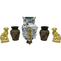 Group of Oriental and Oriental style of ceramics, comprising large blue and white vase embellished with people and gilt detail, pair of seated dogs with a floral decoration on a yellow ground, pair of vases with relief detail, together with stone figure of a fisherman. 