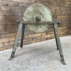 Vintage grindstone sharpening wheel mounted on metal stand, and a cast iron water pump