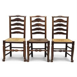 Set of seven (6+1) Georgian design country elm Lancashire dining chairs, ladder backs with rush seats, turned front leg stretcher on pad feet, height of seat 44cm, complete with fitted tie on cushions