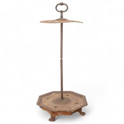 Victorian cast iron cane or stick stand, the top with a large loop lifting handle and floral design above geometric pierced decoration, central vertical rod, and octagonal base with lion paw feet