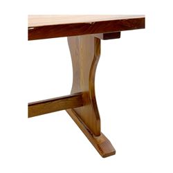 Late 20th century oak trestle table, rectangular top with naturalistic edge, supported by two curved pedestal bases united by central stretcher, on block feet