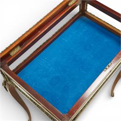 Early 20th century French mahogany bijouterie table, the hinged shaped rectangular top with brass edge and gilt-metal foliate slip enclosing bevelled glass plate, raised on cabriole supports with applied gilt-metal cartouche and foliate mounts