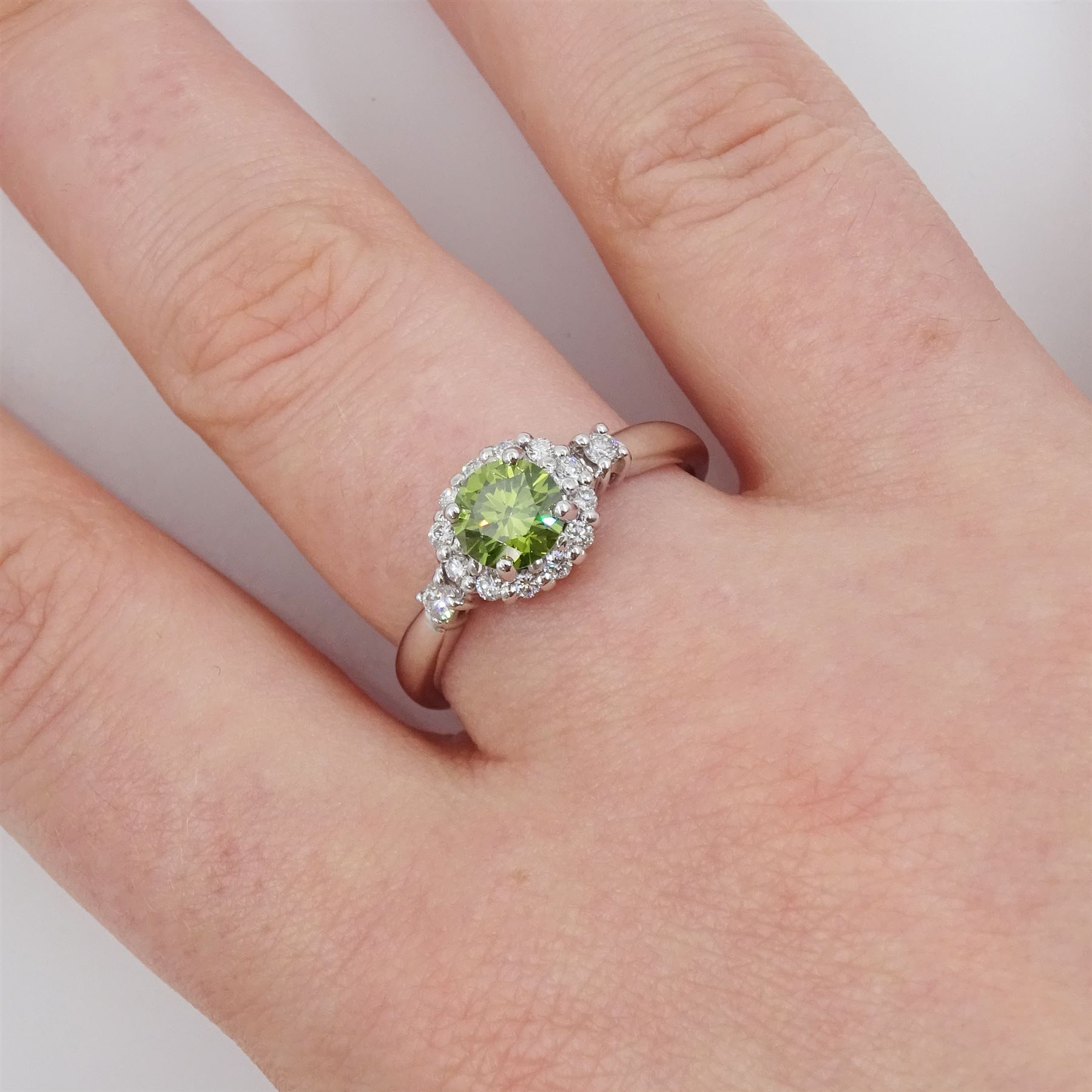 18ct white gold diamond cluster ring, the principal round brilliant cut fancy green diamond of approx 0.65 carat, surrounded by round brilliant cut white diamonds and diamond set shoulders, Birmingham 2007, total white diamond approx 0.20 carat