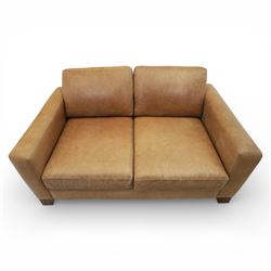 Modern two seat sofa in tanned leather, loose seat and base cushions, block arm rests above dark stained block supports 
