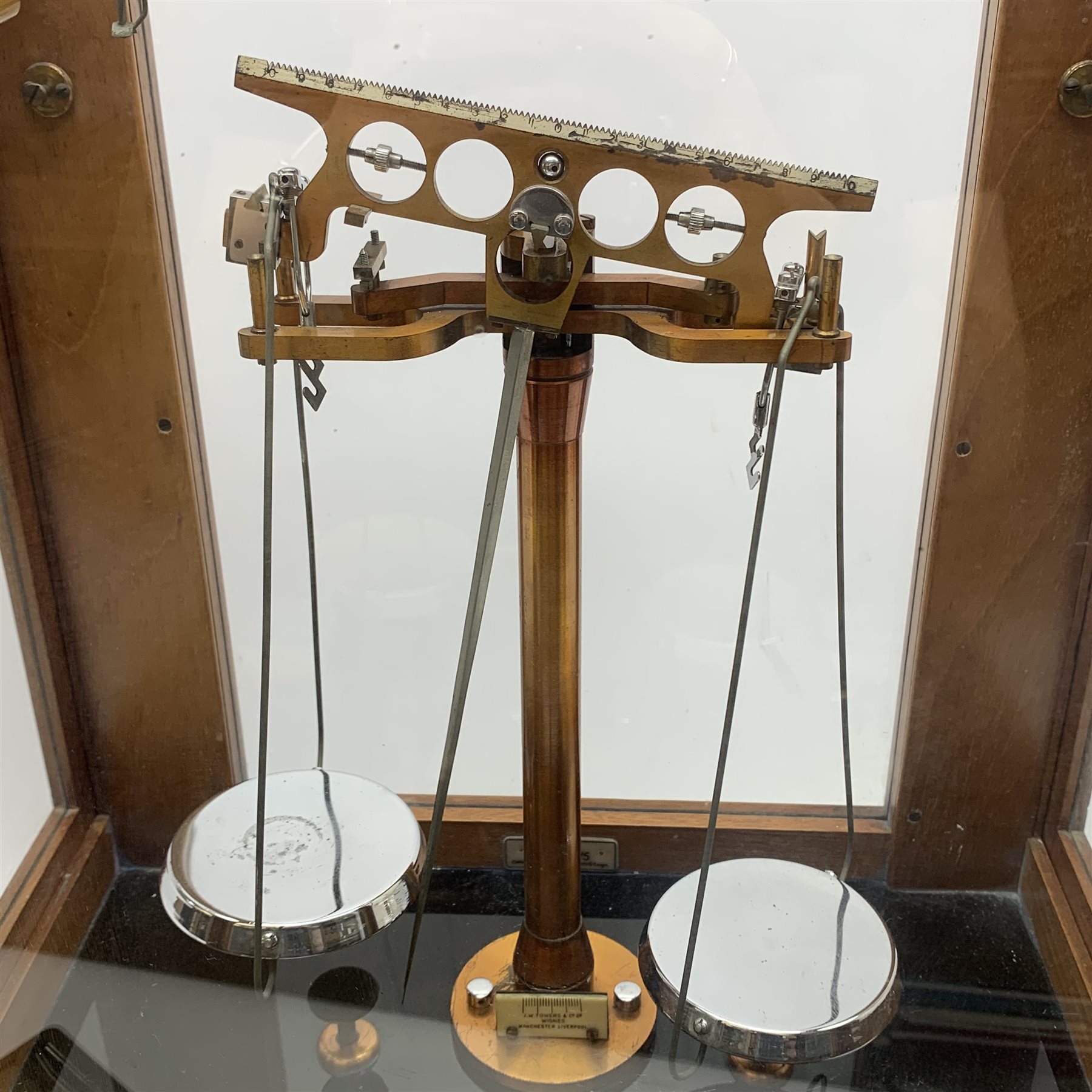 Set of cased brass and chrome laboratory scales by J.W. Towers Widnes Model 75, with black vitrolite type base, upward sliding front and hinged side doors, W40cm H47cm; with bakelite cased set of weights by ETA Instruments Ltd