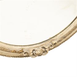 Early 20th century cream and parcel-gilt oval wall mirror with mer-putti pediment