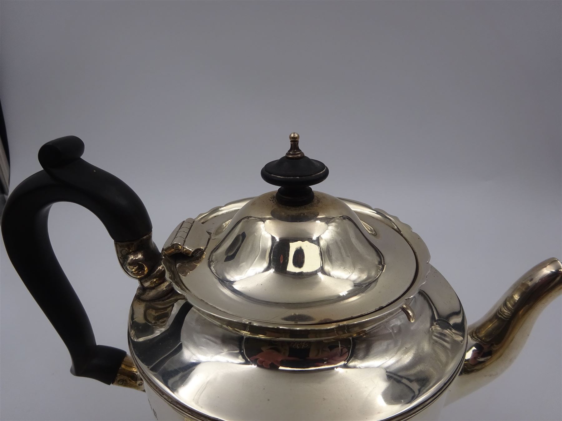 1920s three piece silver tea service, comprising teapot, with ebonised wooden handle and finial, milk jug and open sucrier, all of circular form, with shaped rims, and upon three hoof feet, hallmarked Wakely & Wheeler, London 1922, teapot H19cm