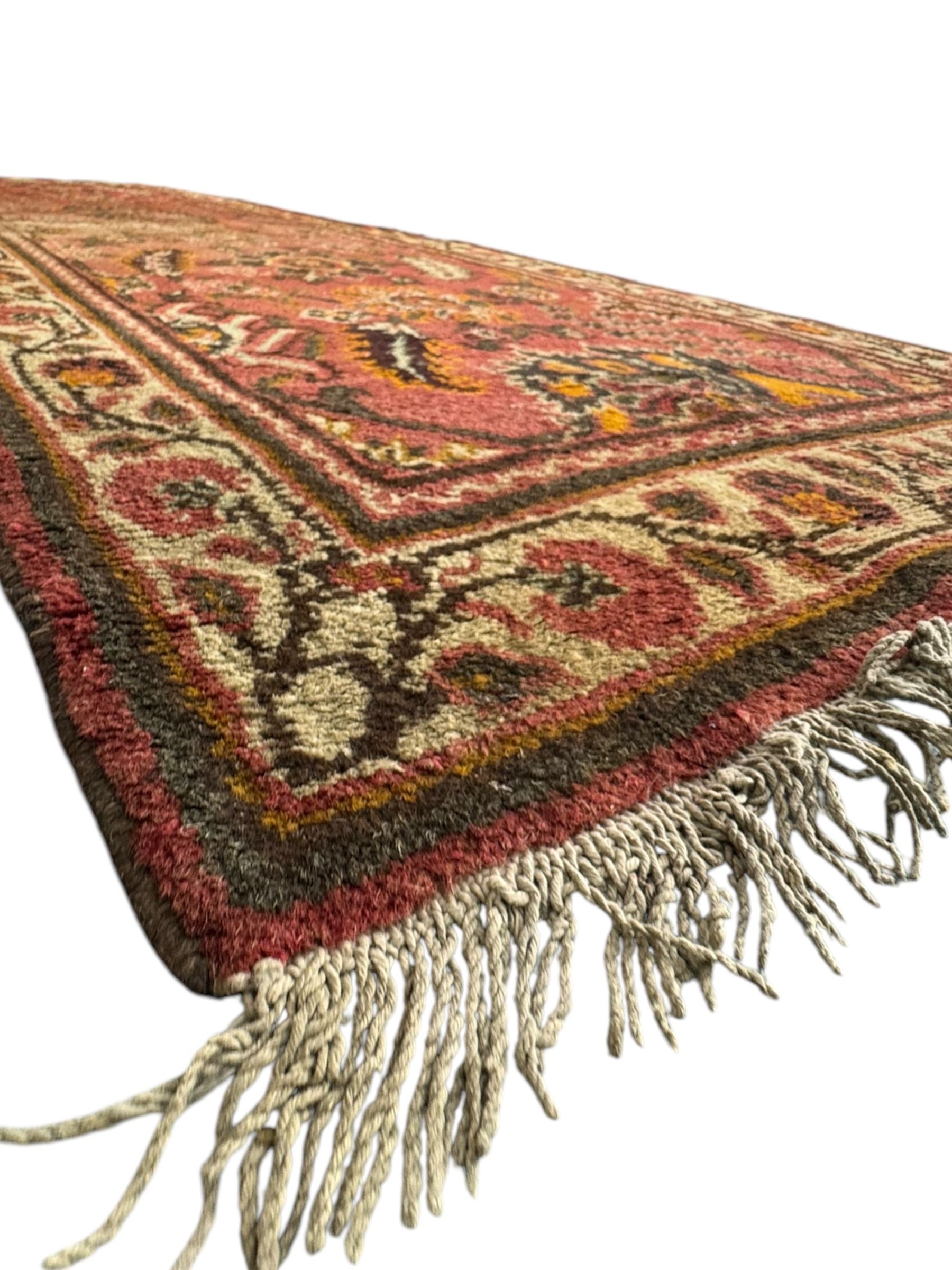 Belgian Sultan woollen ground rug, central navy field densely decorated with floral sprays and geometric patterns (192cm x 135cm); handwoven tribal terracotta ground rug (121cm x 71cm); Persian crimson ground runner, all over stylised floral and foliate motifs (266cm x 94cm)