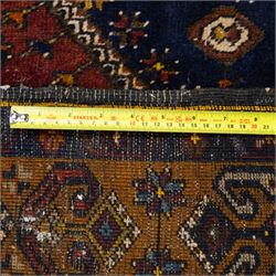 Turkish Anatolian wool rug, central stepped medallion on dark blue lozenge field, red spandrels with stylised hooked motifs, ochre border decorated with repeating geometric motifs and guard stripes