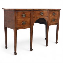 George III Sheraton-style mahogany sideboard, serpentine front fitted with central drawer and flanked by two deep drawers, raised on square tapered legs with spade feet 