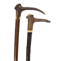 Two stag horn topped walking sticks, each with anthropomorphic handle with glass eyes, one...