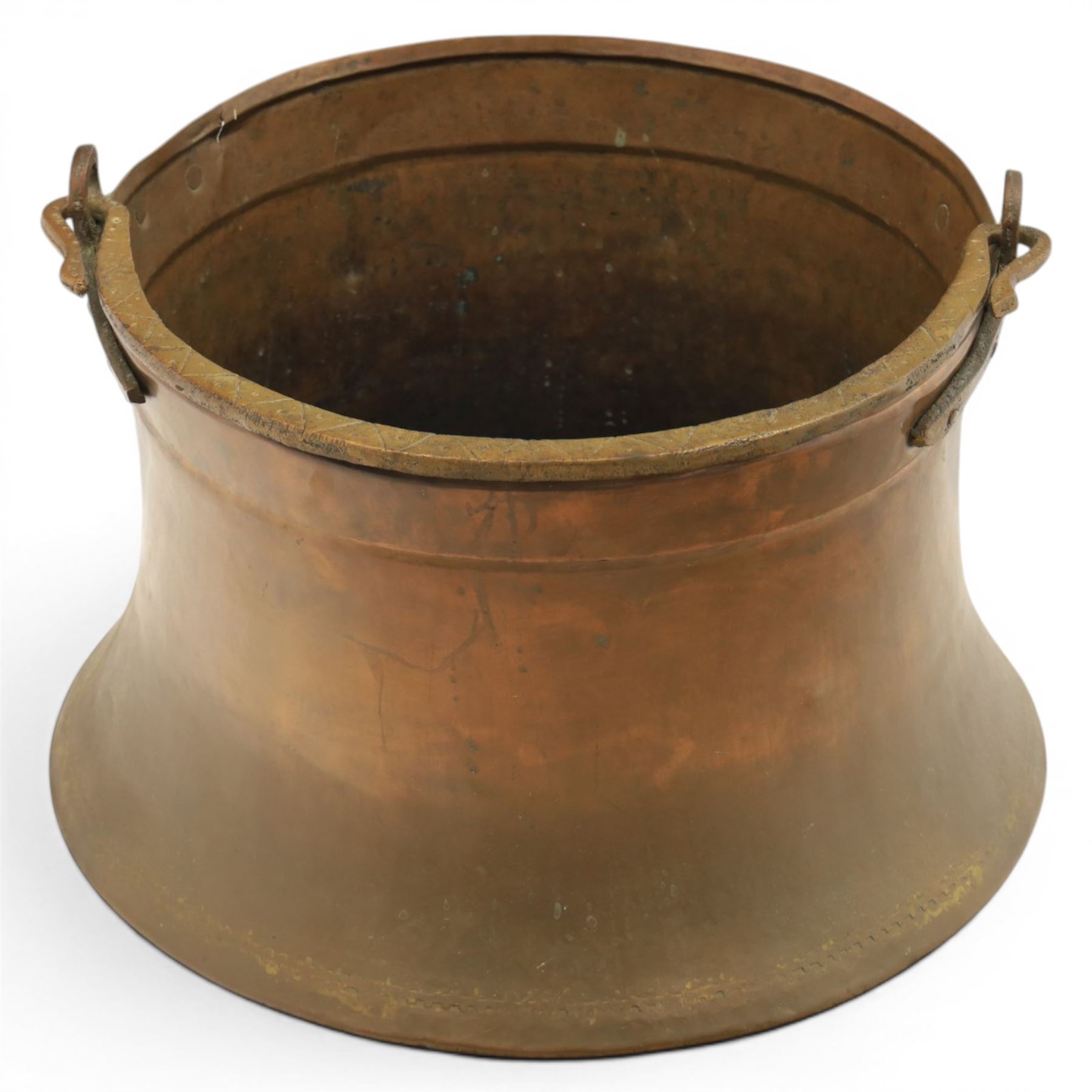 19th century brass and copper cauldron, circular open body with rolled rim, riveted side mounts and swing carrying handle, on broad flared circular foot