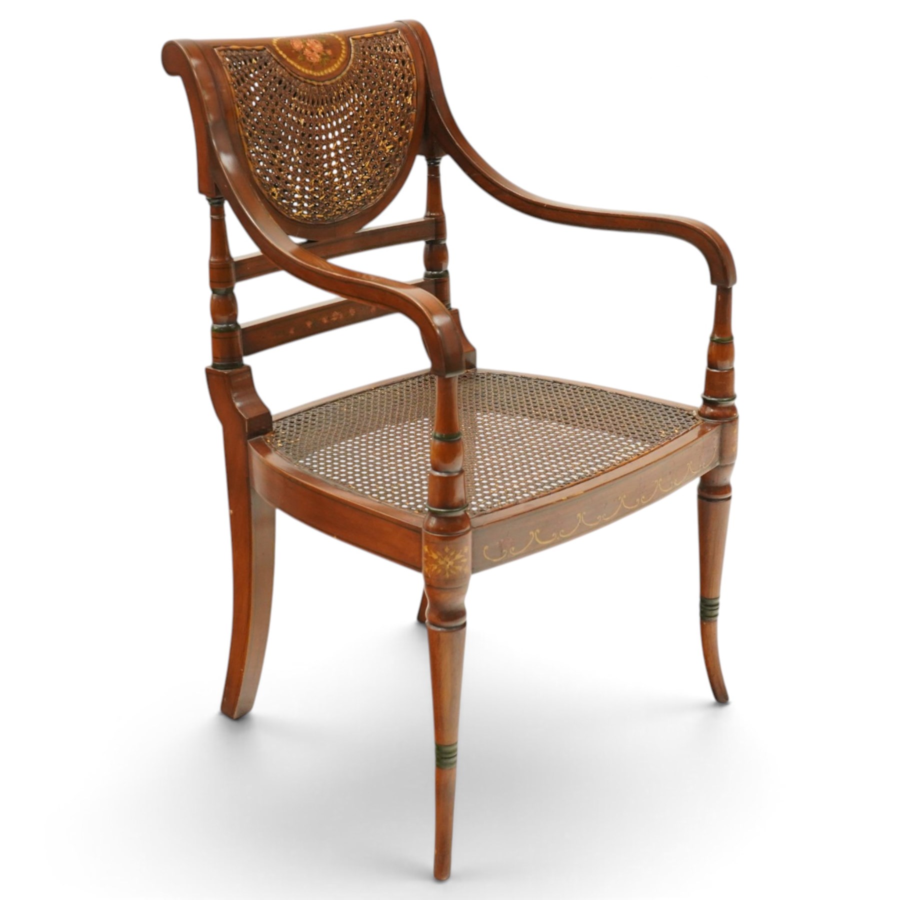 Pair of Sheraton Revival painted mahogany open armchairs, scrolled cresting rail with floral painted decoration over a double-caned back and rose-branch painted back bar, cane seat over C-scroll-painted seat rail, on splayed tapering supports, with all-over painted ebony faux stringing