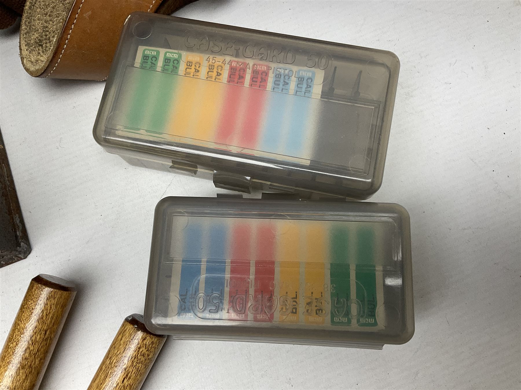 Assorted militaria including ten leather or canvas cartridge and other belts, maroon beret with 17th Lancers cap badge, modern bullet mould, leather and brass shot flask, two knives, shell cases, boomerang etc; in tin deed box