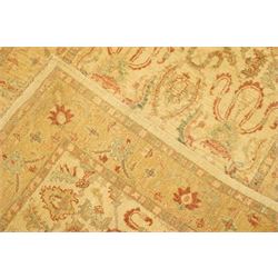 Ziegler design hand-knotted wool rug, the central field with symmetrical scrolling floral motifs in muted tones of beige, sage green, and terracotta, within a conforming border, all on a soft ivory ground