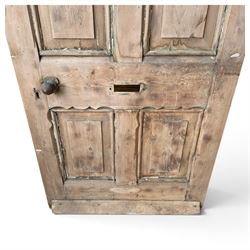 Victorian stripped pine four-panel door, the raised fielded panels within carved foliate and moulded surrounds, with iron lock and fittings and brass knob handle