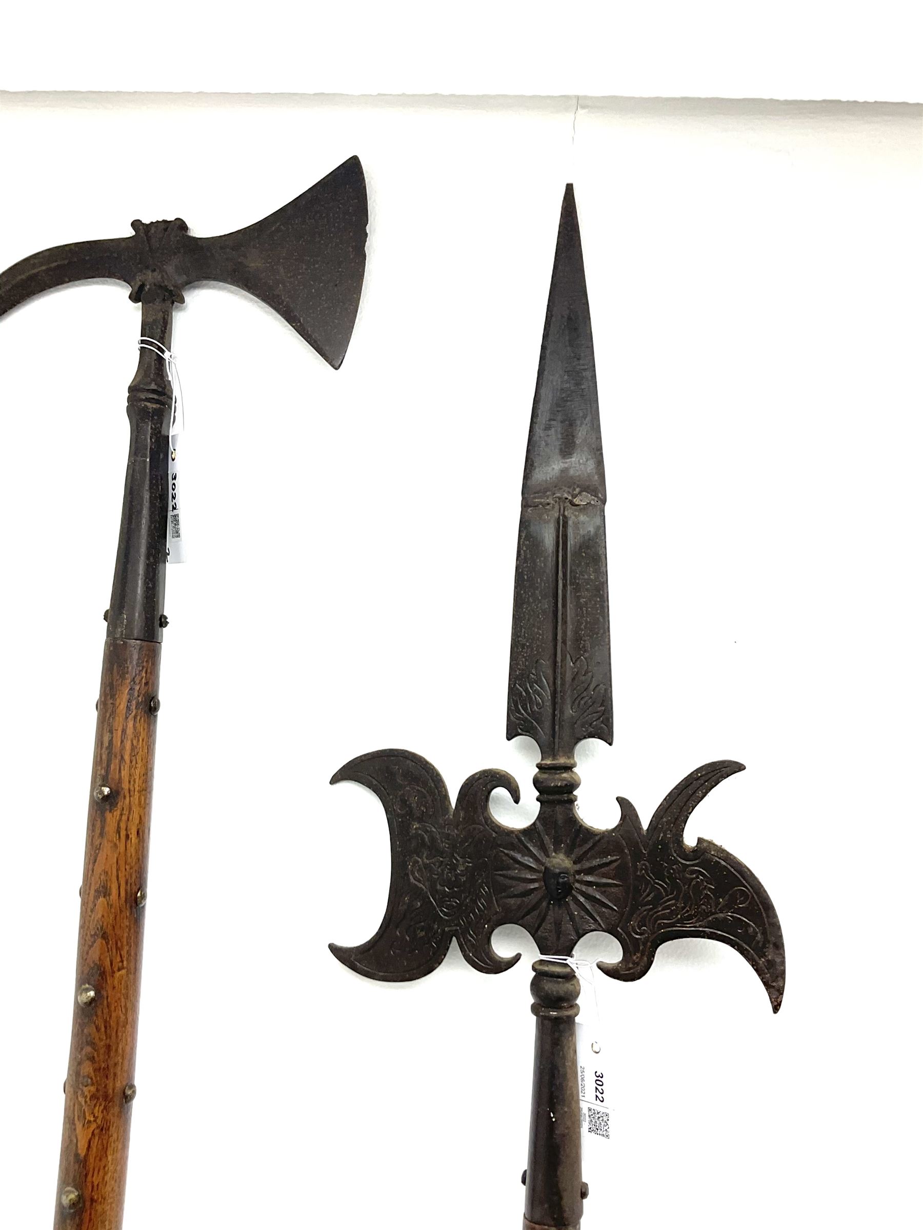 Large continental steel halberd axe the engraved blade with cast sunburst centre and long studded ash handle L219cm; and another halberd with plain ribbed blade and studded ash handle with ground spike (2)