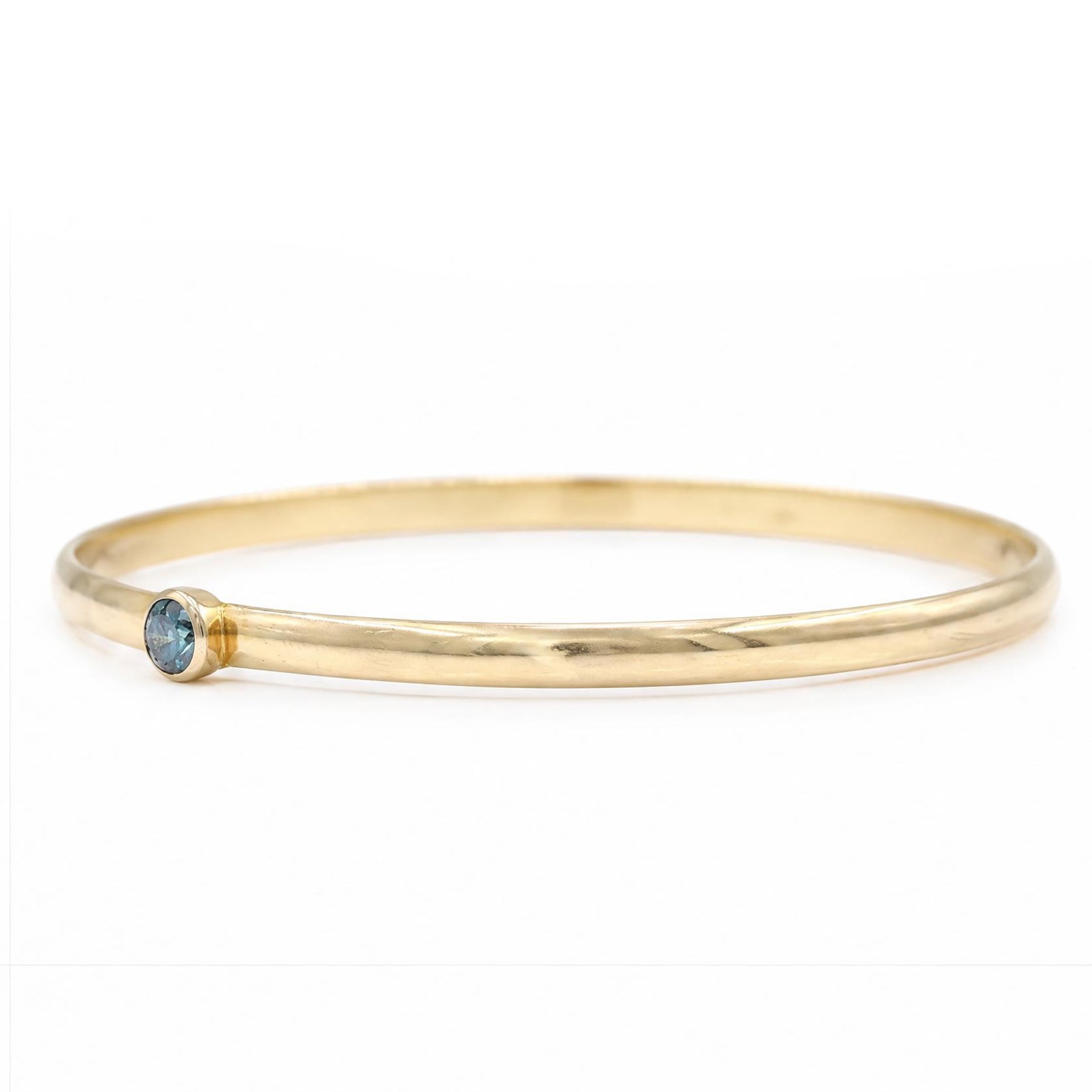18ct gold fancy blue diamond bangle, bezel set with a single round brilliant cut diamond of approx 0.35 carat, stamped 750