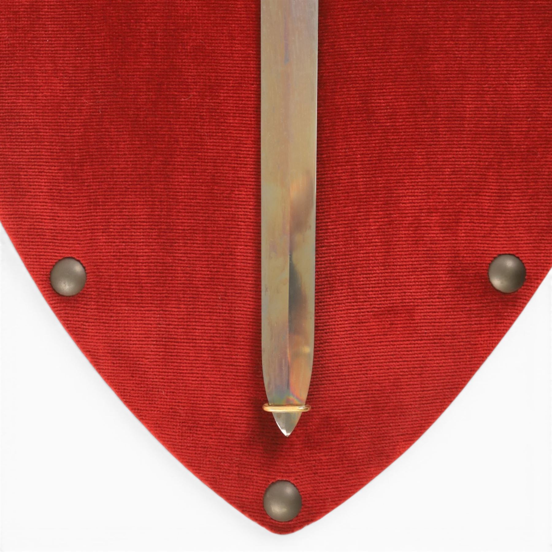 Three replica gauntlets, each housed upon a red wall shield, two with daggers, the third with a sword, largest H102cm