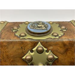 Victorian brass banded walnut tea caddy of sarcophagal form, the hinged lid inset with a Wedgwood blue jasper ware plaque of a winged cherub playing a harp on the back of a lion, the interior with two covered containers with brass mounts detailed with the letters B and G and a Wedgwood & Sons 9 Cornhill plaque, H16.5cm W28.5cm D15cm