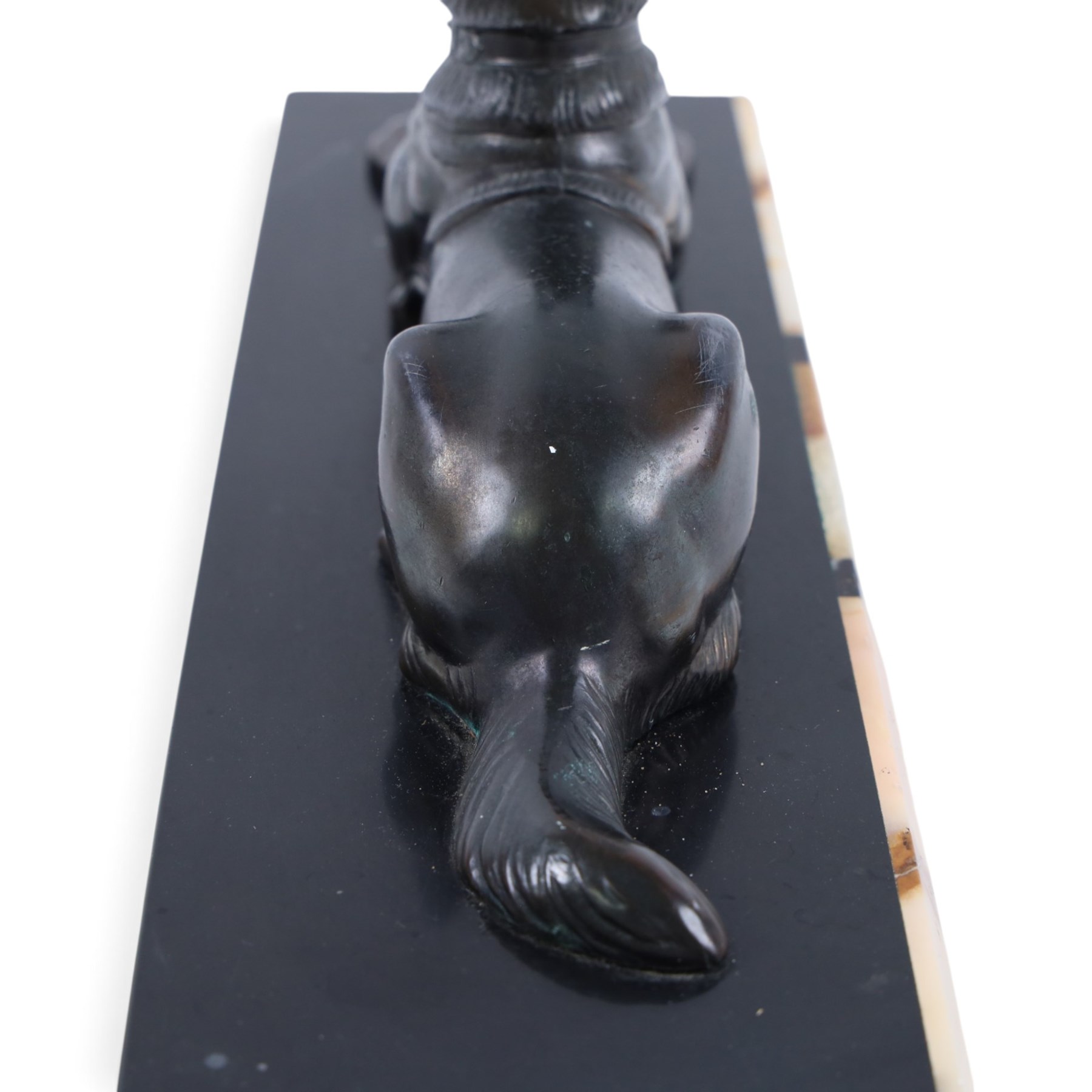 French Art Deco spelter figure of a recumbent dog on marble and onyx plinth, H14cm, L30cm