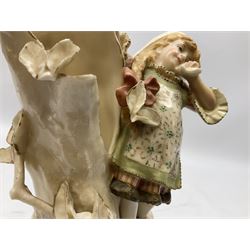Late 19th century continental spill vase as a young girl standing beside an open tree trunk H21cm; and three German bisque figures (4)