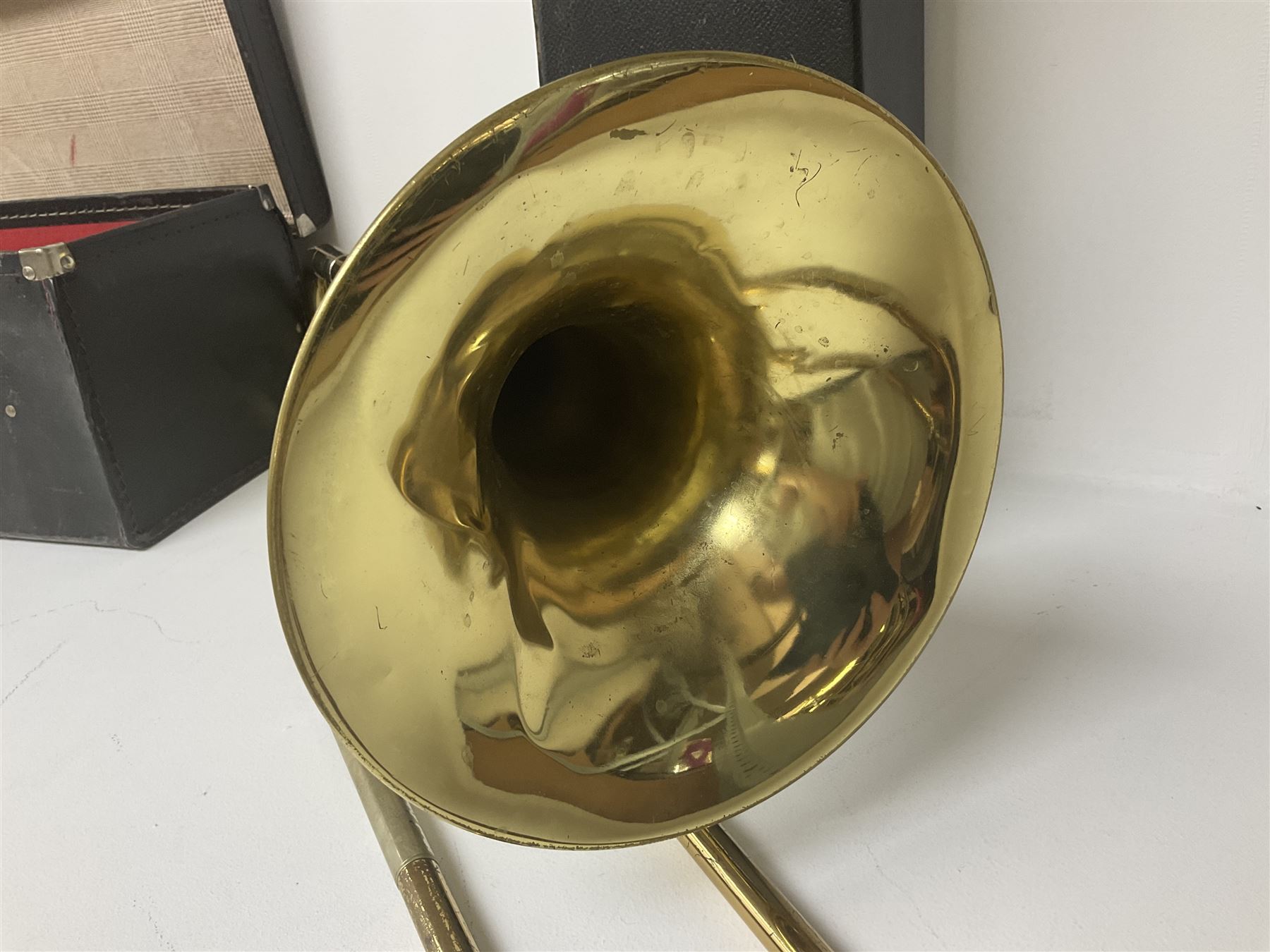 Three brass trombones comprising Elkhart Ind. USA 'CONN' model no.72H; Besson 'Concord'; and Selmer Distributed 'Lincoln'; two in carrying cases; and German B & M 'Champion' brass trumpet (4)