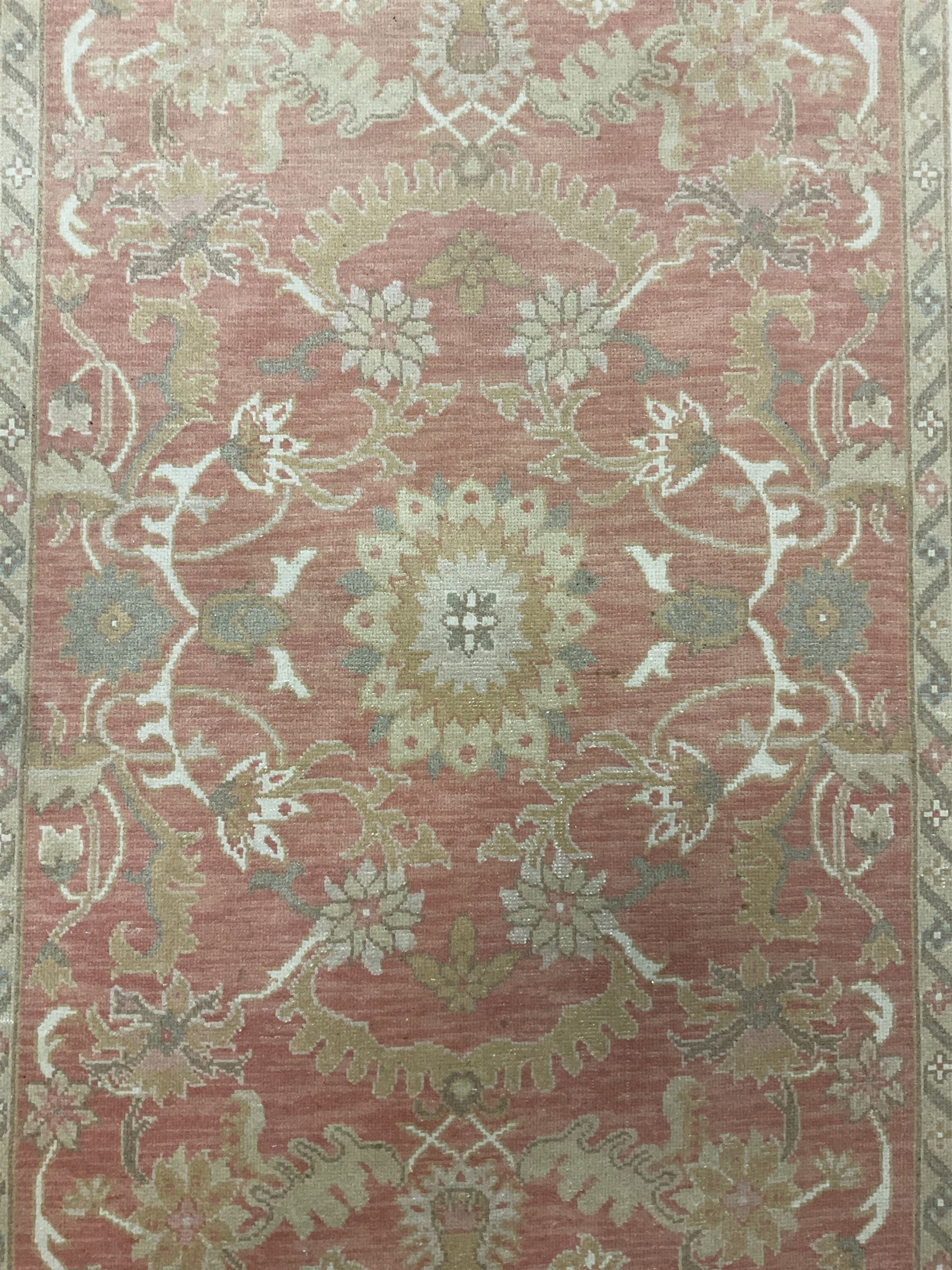 Persian Zeigler design rug, peach ground decorated with trailing branches and stylised plant motifs, the guarded border decorated with further plant moitfs