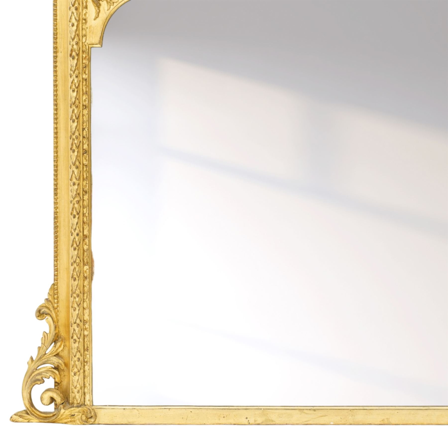 Victorian giltwood and gesso framed overmantel mirror, the scallop shell pediment with trailing acanthus leaves over a foliate moulded slip with beaded outer-edge, of rectangular arced form with floral spandrels, the base with further extending pierced scrolling acanthi decoration