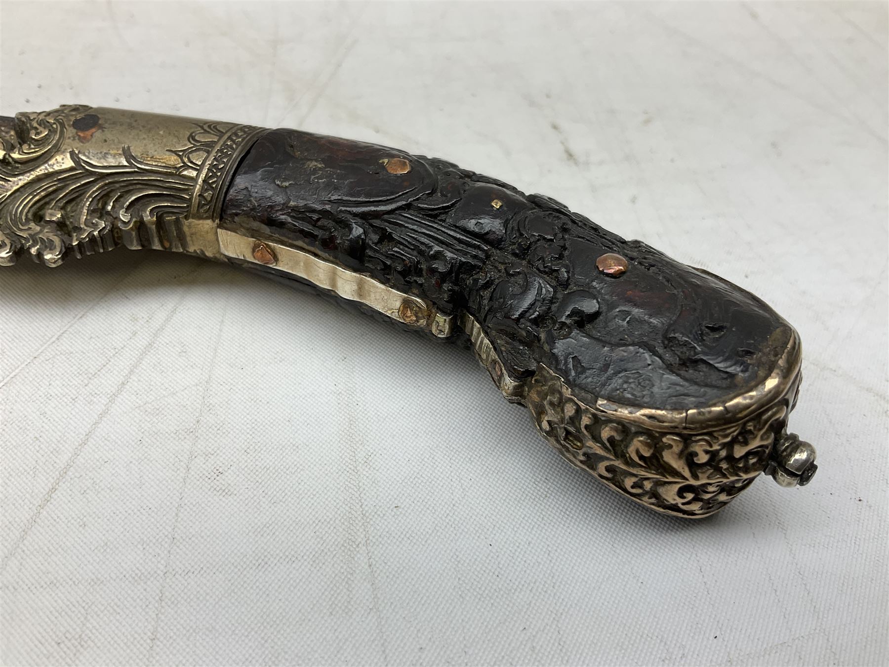 19th century Singhalese knife pia kaetta, the 20cm steel blade inset with yellow and white metal, with metal mounted carved pistol grip, in plain wooden scabbard L33cm overall