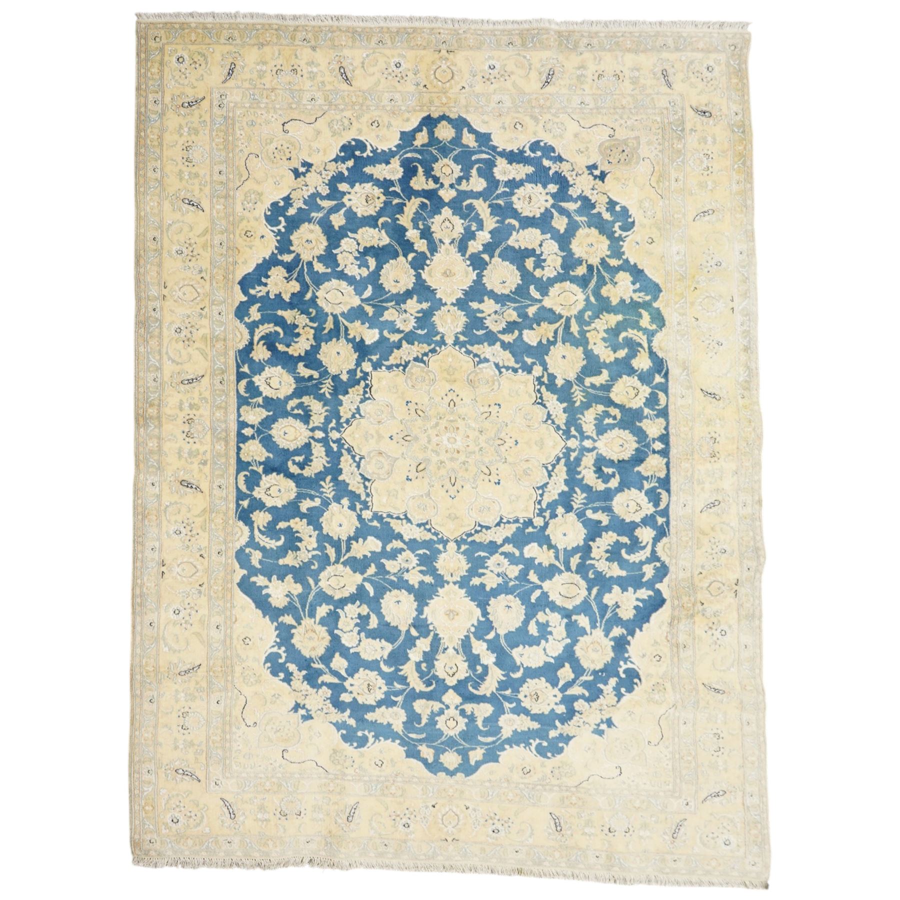 Central Persian Nain hand-knotted rug, sky blue field, with a central cusped medallion in ivory and soft camel tones, issuing an elegant arrangement of scrolling arabesques, palmettes and flowering vines, conforming ivory spandrels, principal pale border decorated with floral sprays and palmettes, flanked by narrow ground borders, with cotton fringe ends  