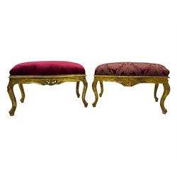 Pair of Louis XV-design giltwood stools, each upholstered in red damask fabric with slight variations in patterns, the carved frames adorned with scrolling foliage and shell motifs, raised on cabriole supports
