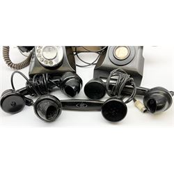 Two vintage black Bakelite telephones, one with a rotary dial and one 'call to exchange', together with three spare Bakelite handsets and additional telephone spare parts. 