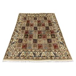 Persian Heriz design rug, ivory ground with rectangular panels each depicting garden scenes of tree of life, plants and Boteh motifs, the guarded border decorated with wildlife and bird scenes