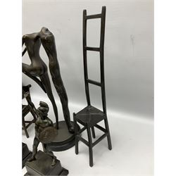 Bronze figure of a female nude with long flowing hair in stretched pose raised on circular base, supporting candlestick holder, together with bronze figure of a girl stood upon a chair, two warrior figures etc (5)