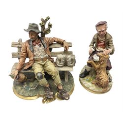 Two 20th Century Capodimonte tramp figures to include example seated on a bench beside bag on gilt lined scroll base, both with stamped marks beneath
