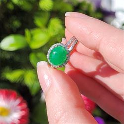 Platinum jadeite and diamond cluster ring, single oval cabochon cut jadeite of 2.20 carat, surrounded by round brilliant cut diamonds and diamond set shoulders, stamped Plat