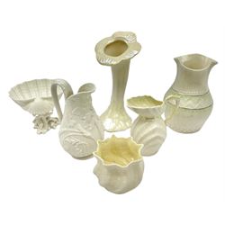 Quantity of Belleek ceramics to include mid-late 19th century jug moulded with green man mask and foliage, date code stamp for 1863-1890, together with later Belleek cornucopia shape vase, jug and other vases together with a Belleek style shell dish raised on branches, tallest H19cm