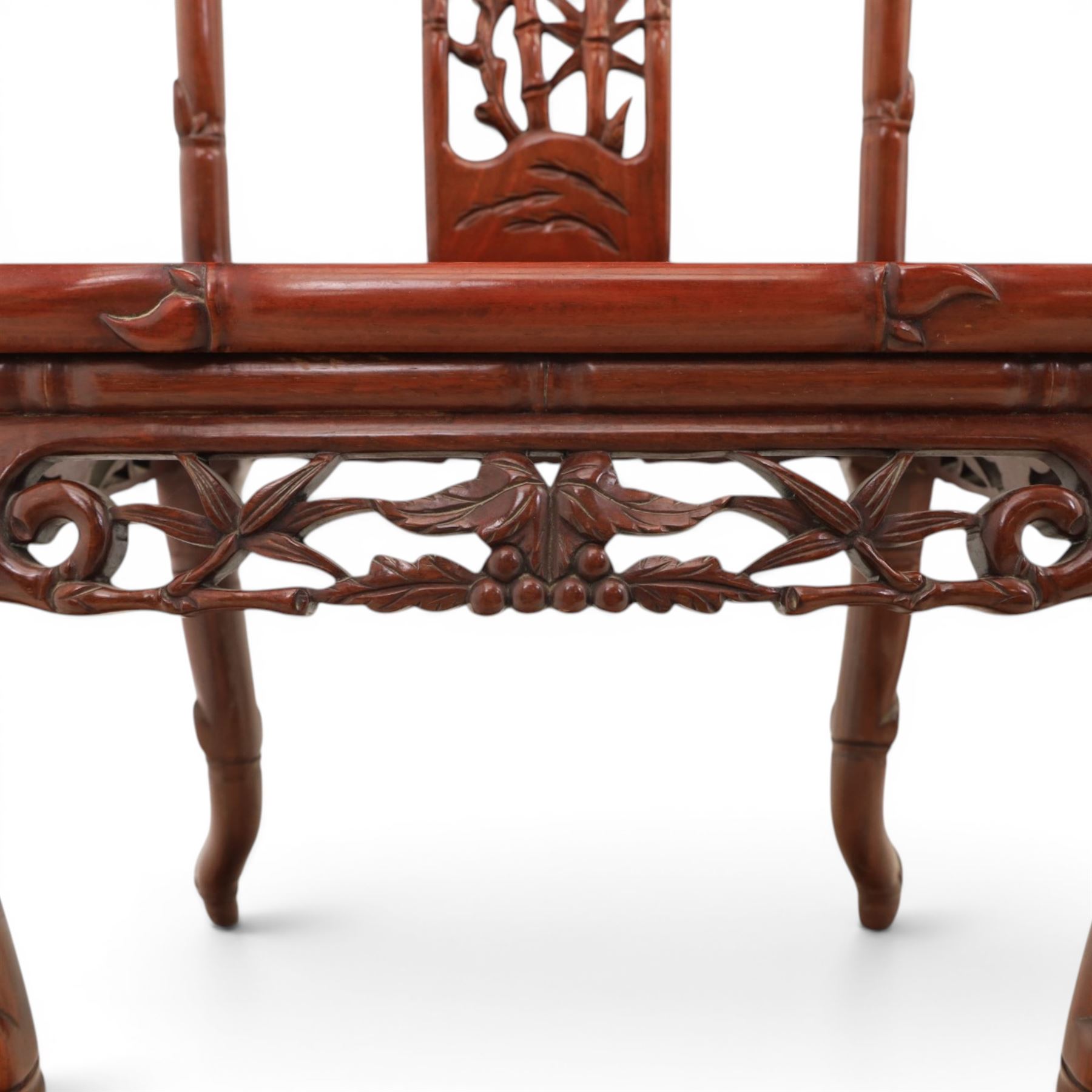 20th century Chinese ornately hardwood dining table and chairs, circular table with 'Lazy Susan' top with pierced carved frieze, raised on a quadriform base with carved foliate detail, the chairs en suite with carved pierced detailing  