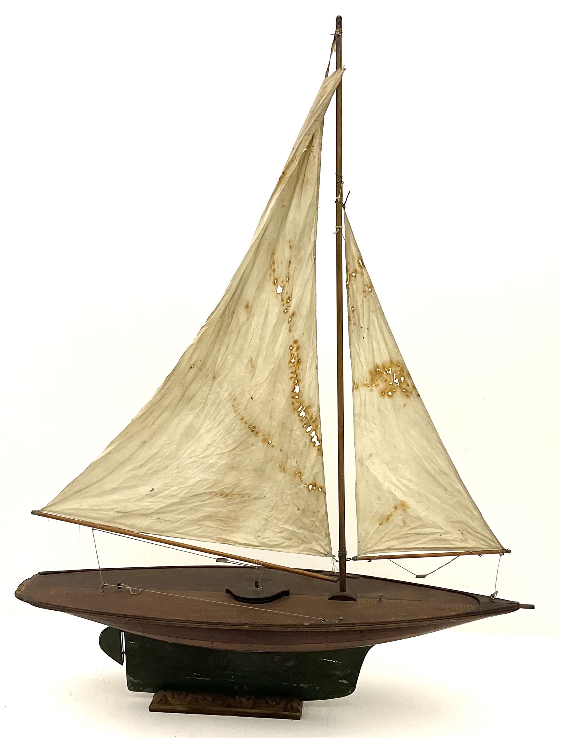 Large Victorian pond yacht, the planked hardwood hull with large lead weighted keel and working rudder, simulated planked deck and single mast with original sails; on later scratch-built wooden stand L117cm H151cm