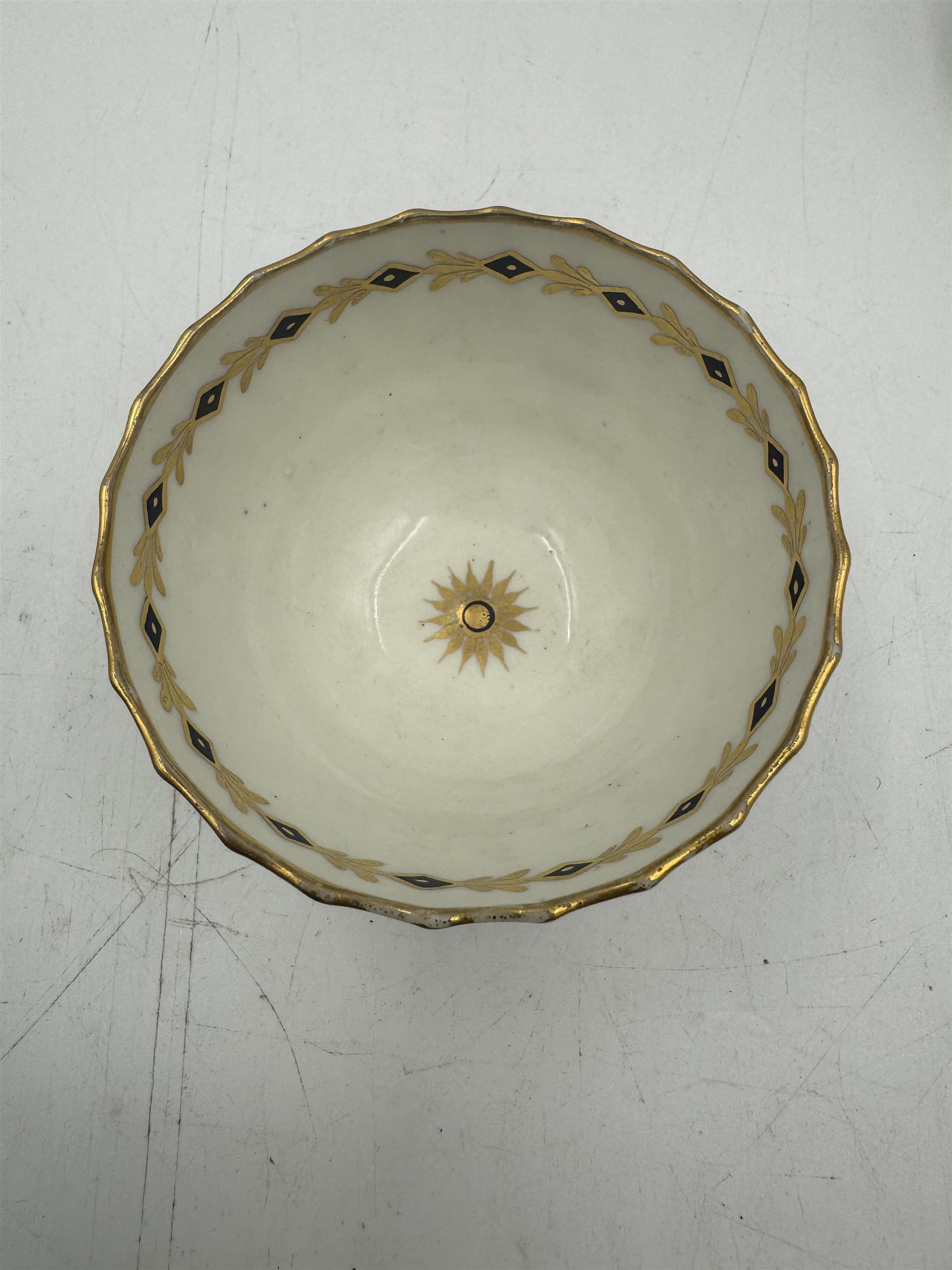 18th century Caughley blue and white sparrow jug, decorated in the Mother and Child pattern, circa 1780-1790, with underglaze C mark beneath, H9cm, together with a Worcester coffee cup, circa 1785 painted with floral sprays in underglaze blue and gilt, with crescent mark beneath, and a Caughley trio of tea cup, tea bowl and saucer, each of moulded wrythen fluted form and decorated with gilt and blue sprigs and bands, each with crescent mark beneath, (5)