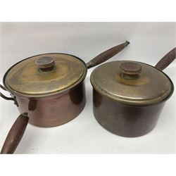 Four Victorian copper moulds, together with a graduating set of copper pans with wooden handles and finials to covers, largest pan 