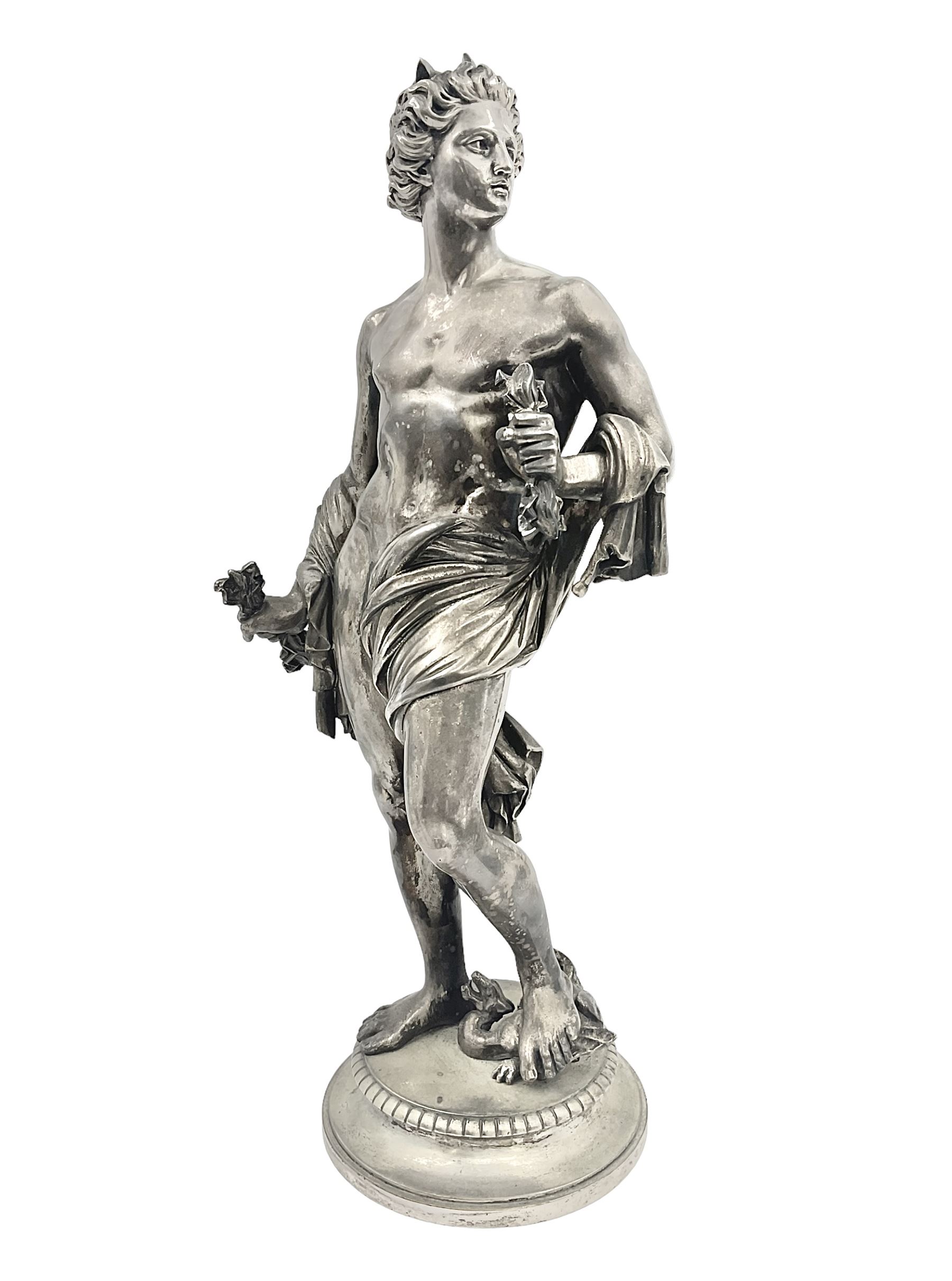 20th century silver plated figure, modelled as a classical male figure, possibly Prometheus, holding flames, one foot resting atop a small dragon, upon a circular spreading base, overall H37.5cm