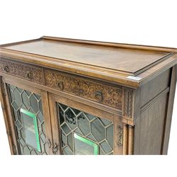 Edwardian rosewood display cabinet, rectangular top over two drawers with blind fretwork facias, enclosed by two doors with lead glazed and bevelled panels, turned half column pilasters terminating into cluster column supports, united by undertier with raised fretwork gallery, on turned feet