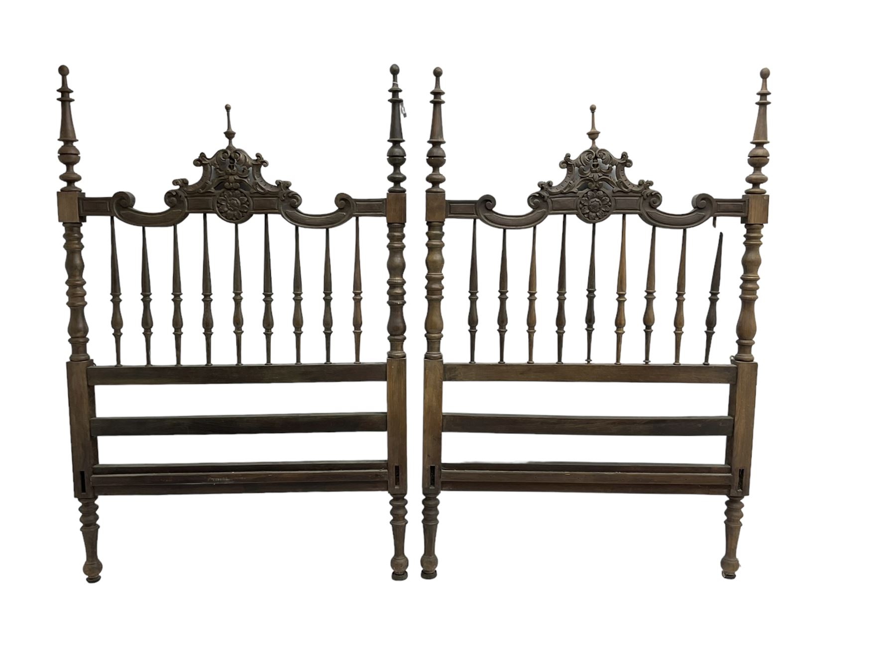 Pair Spanish stained beech single 3' bedsteads, spindle turned backs and carved with scrolling floral decoration 