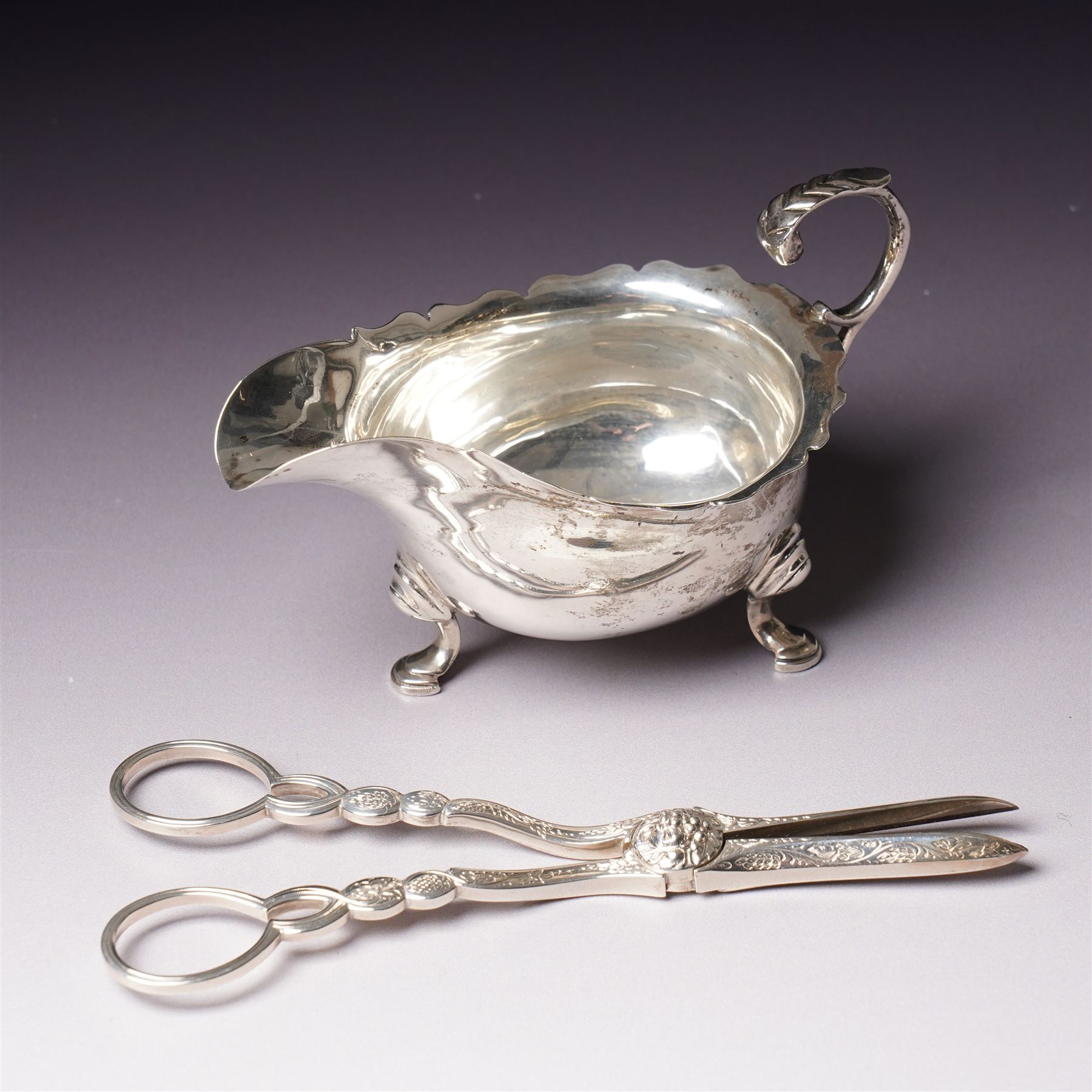Pair of Victorian silver grape scissors with engraved decoration Birmingham 1860 Maker probably John Gilbert and a small silver sauce boat with crimped rim and C scroll handle Birmingham 1905 Maker Thomas Hayes (2)  
