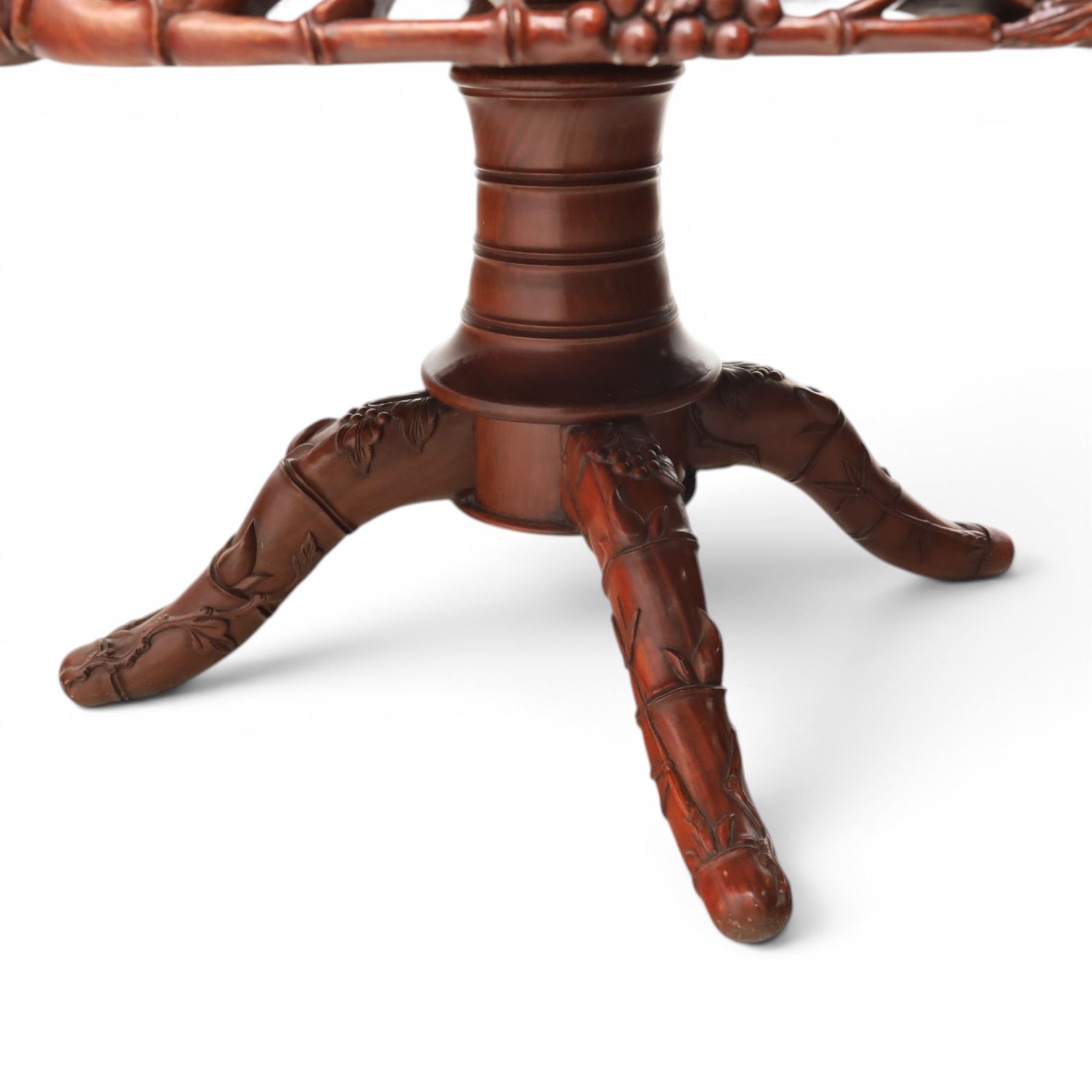 20th century Chinese ornately hardwood dining table and chairs, circular table with 'Lazy Susan' top with pierced carved frieze, raised on a quadriform base with carved foliate detail, the chairs en suite with carved pierced detailing  
